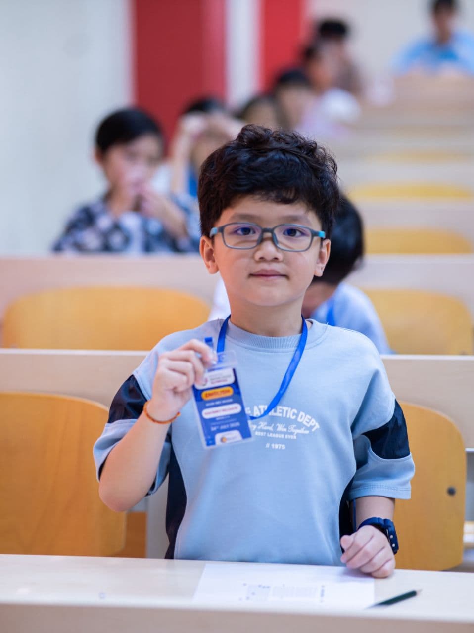 Student holding an English badge