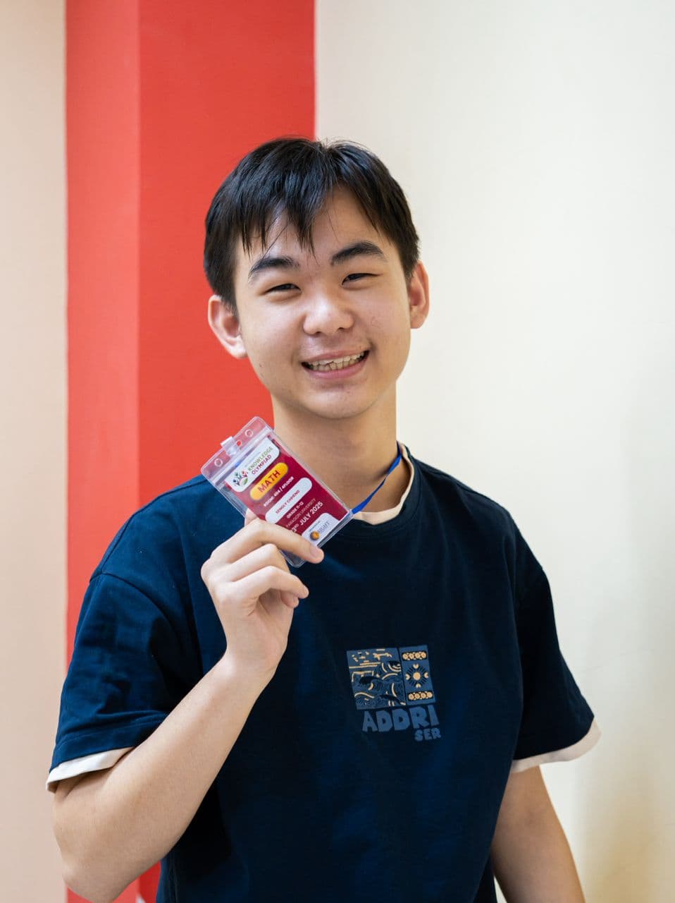 Student holding a Maths badge