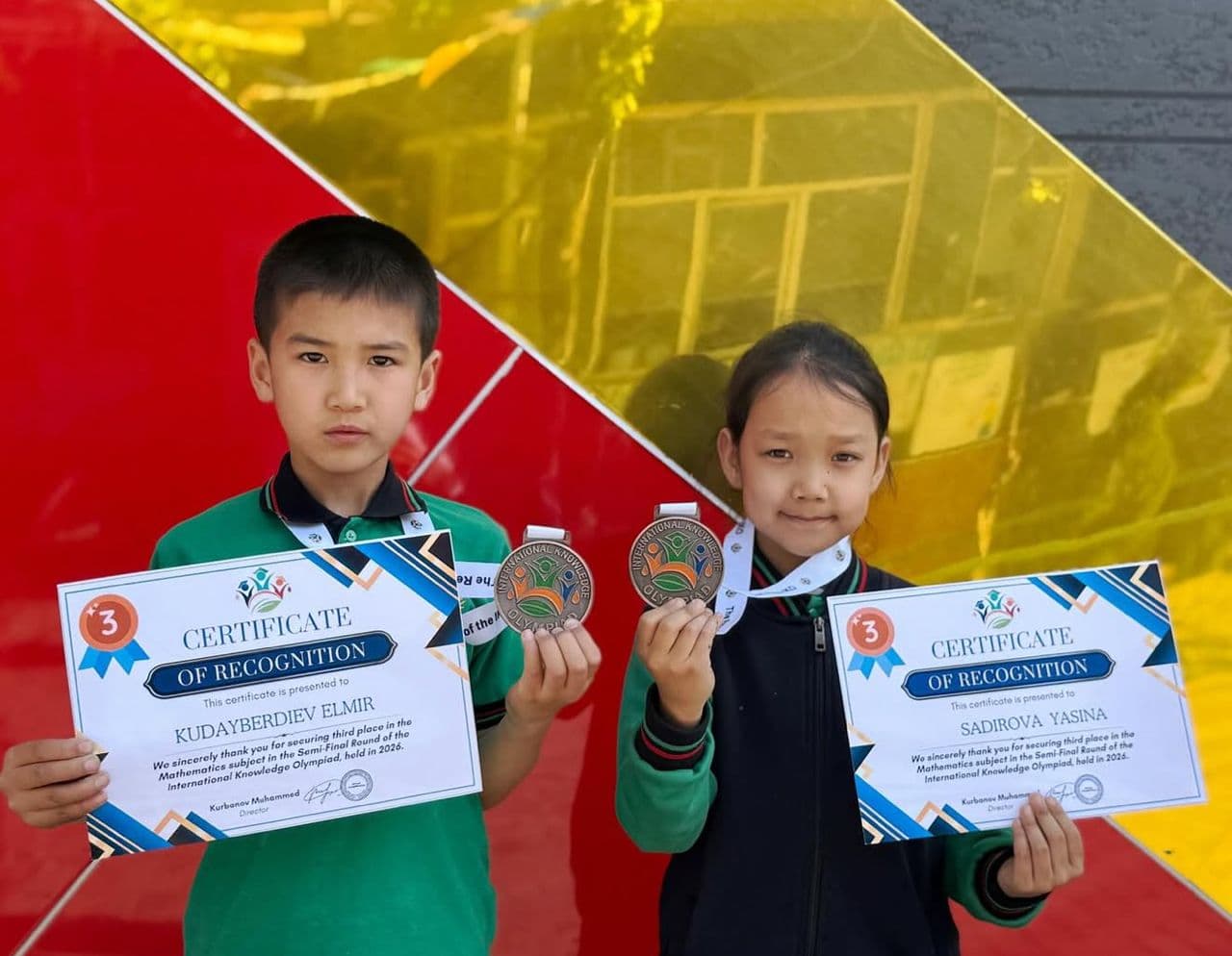 Two students holding certificates